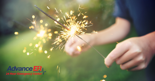 boy lighting a sparkler on the fourth of july